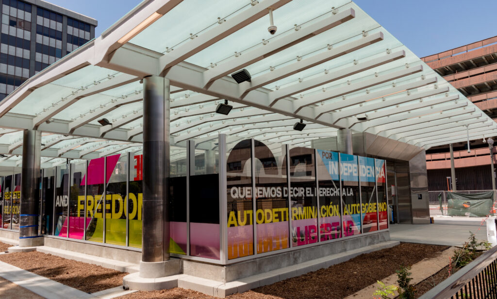 This image illustrates a link to the exhibition titled Andrea Bowers installation for MTA opens at the Historic Broadway station