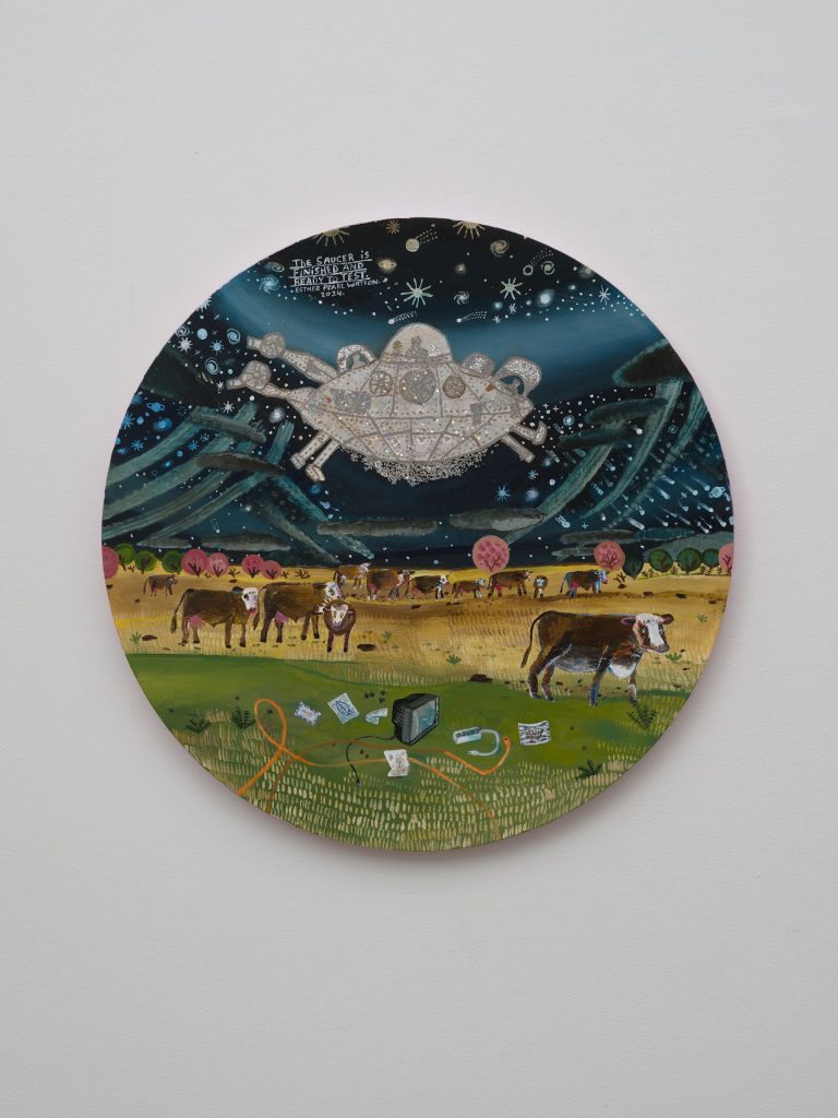 This image depicts an artwork by Esther Pearl Watson titled "The Saucer is Finished and Ready to Test." This artwork was created in 2024 and measures 24" [Diameter] (60.96 cm). Its medium is Acrylic and mixed media on panel.
