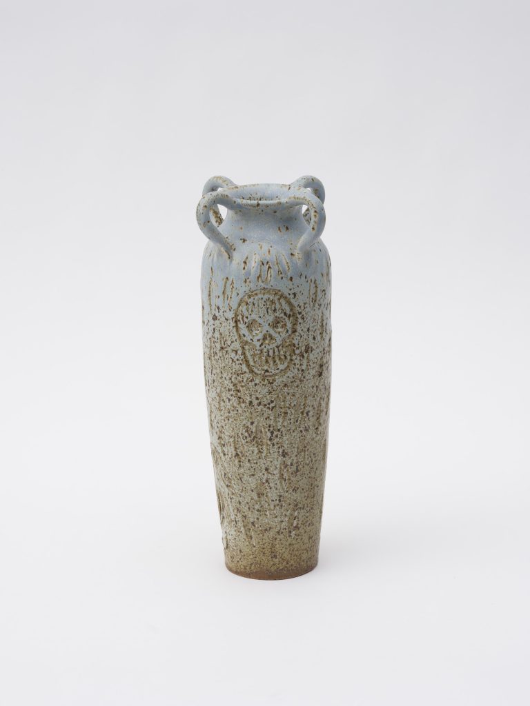 This image depicts an artwork by Stanya Kahn titled "Powder blue four handle skull and bird vase." This artwork was created in 2022 and measures 14" x 6" [HxW] (35.56 x 15.24 cm). Its medium is Glazed stoneware.