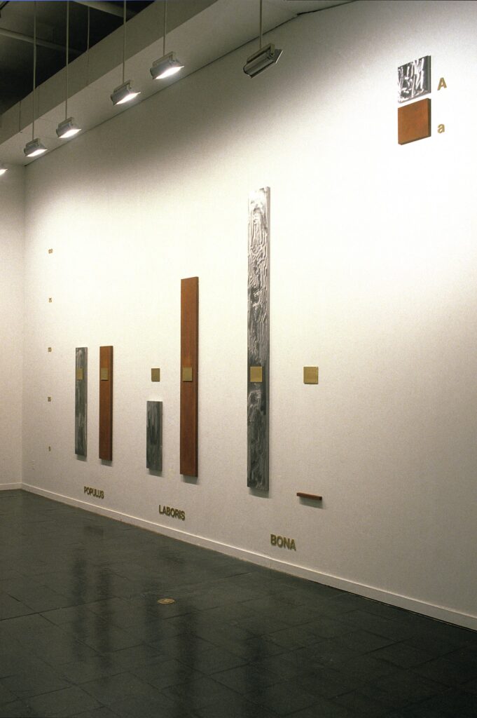 This image depicts an artwork by Mary Kelly titled "Interim, Part IV: Potestas." This artwork was created in 1989 and measures 14 Units: 8' 4" x 9' 6" x 2" [HxWxD] (254 x 289.56 x 5.08 cm) overall. Its medium is Etching, brass, and mild steel.