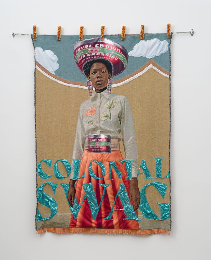 This image depicts an artwork by April Bey titled "Y'all Hoes Have to Make Up Shit to Pretend That I'm Not That Bitch.." This artwork was created in 2025 and measures 80" x 60" [HxW] (203.2 x 152.4 cm). Its medium is Jacquard textiles, hand-sewn sherpa fabric, adorned jumbo clothespins, ponytail beads.