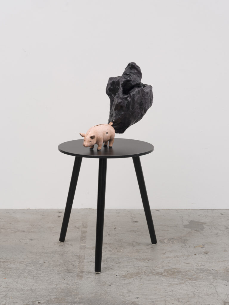 This image depicts an artwork by Rodney McMillian titled "Piggy Bank (where the sun doesn't shine)." This artwork was created in 2024-2025 and measures 14" x 17" x 8" [HxWxD] (35.56 x 43.18 x 20.32 cm). Its medium is Piggy bank, chicken wire, fabric, and acrylic.