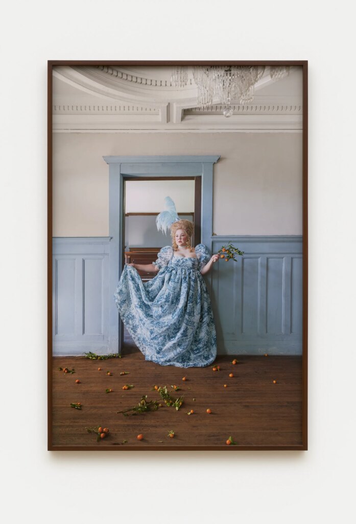 This image depicts an artwork by Genevieve Gaignard titled "Off With Their Heads: Ruminate." This artwork was created in 2022 and measures 60 ³⁄₄" x 40 ³⁄₄" x 2" [HxWxD] (154.3 x 103.5 x 5.08 cm) framed60" x 40" [HxW] (152.4 x 101.6 cm) print size. Its medium is Chromogenic print.