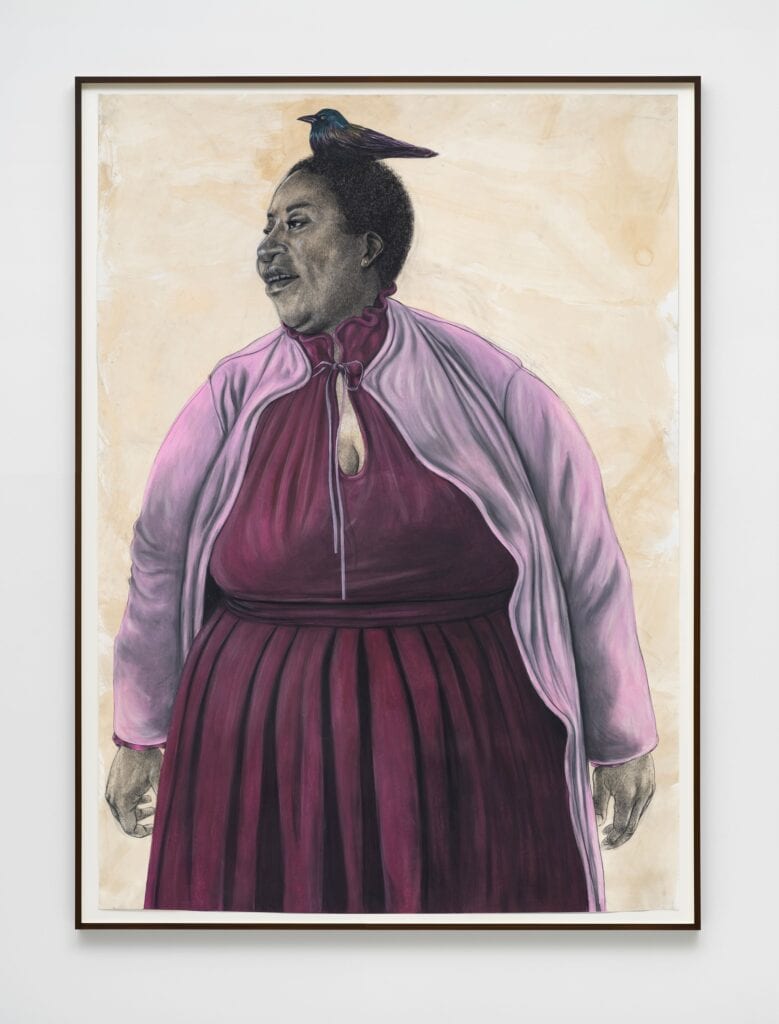 This image depicts an artwork by Robert Pruitt titled "Pink Lady with a Grackle." This artwork was created in 2026 and measures 84" x 60" [HxW] (213.36 x 152.4 cm) 88" x 64 ¹⁄₂" x 2" [HxWxD] (223.52 x 163.83 x 5.08 cm) framed. Its medium is Charcoal, Conté, pastel, coffee wash on paper.