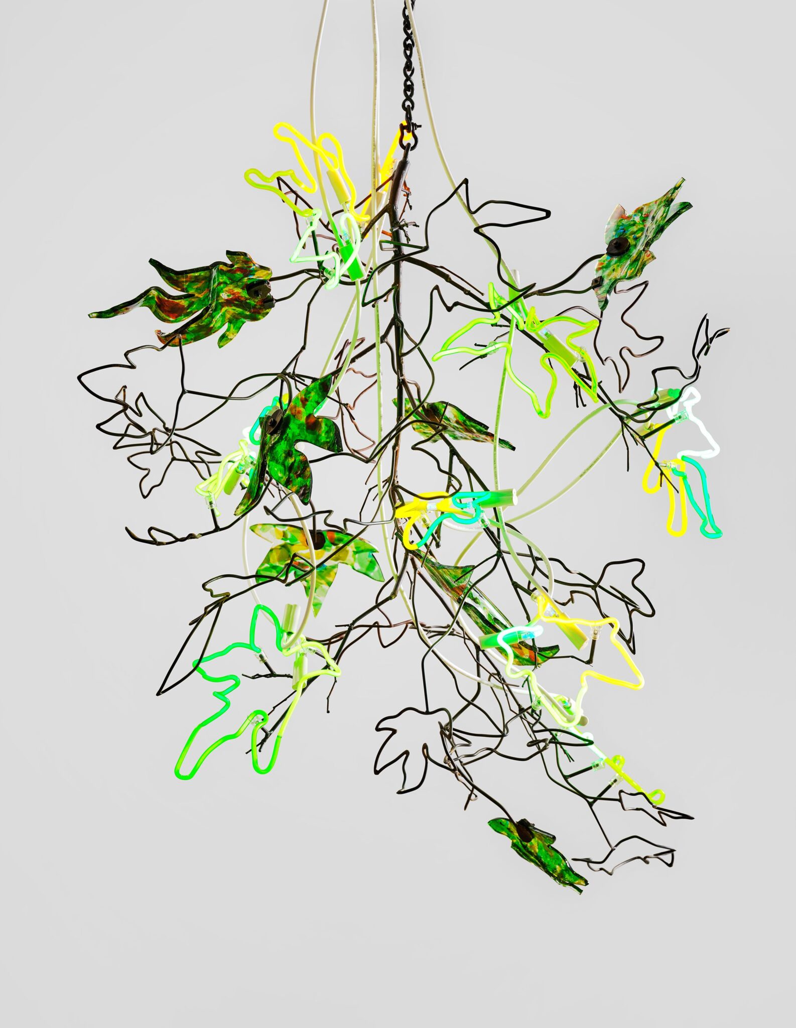This image depicts an artwork by Andrea Bowers titled "Chandeliers of Interconnectedness (Her Leaves Are Fists, Quote by Deena Metzger)." This artwork was created in 2024 and measures 55" x 52" x 54" [HxWxD] (139.69 x 132.08 x 137.16 cm) . Its medium is Steel, neon glass tubes, fused glass, transformers and cables.