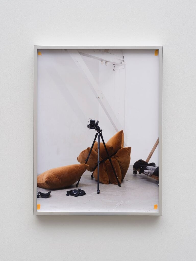 This image depicts an artwork by Paul Mpagi Sepuya titled "Studio Mirror with Kneepads and Straps (_DSF2417)." This artwork was created in 2024 and measures 24" x 18" [HxW] (60.96 x 45.72 cm) print size 24 ³⁄₄" x 18 ³⁄₄" x 2" [HxWxD] (62.86 x 47.62 x 5.08 cm) unglazed framed. Its medium is Archival pigment print.