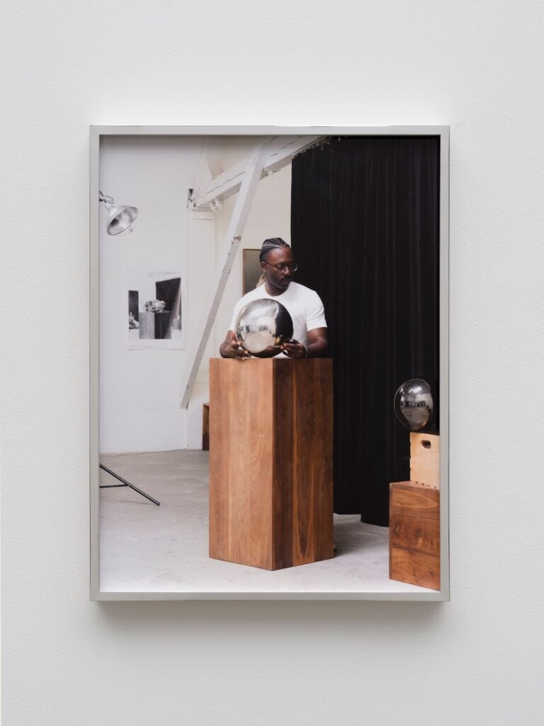 This image depicts an artwork by Paul Mpagi Sepuya titled "Studio Mirror Self-portrait (_DSF9607)." This artwork was created in 2023 and measures 24" x 18" [HxW] (60.96 x 45.72 cm) print size 24 ³⁄₄" x 18 ³⁄₄" x 2" [HxWxD] (62.86 x 47.62 x 5.08 cm) unglazed framed. Its medium is Archival pigment print.